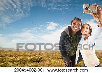 Stock Photography - two young woman 
taking self portrait 
outdoors, smiling. 
fotosearch - search 
stock photos, 
pictures, images, 
and photo clipart