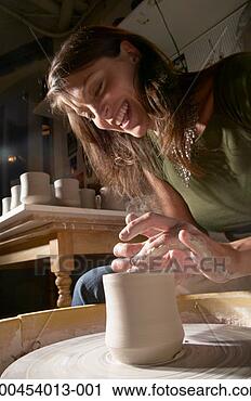 Stock Photography - woman making vase 
on pottery wheel, 
smiling, low angle 
view. fotosearch 
- search stock 
photos, pictures, 
images, and photo 
clipart