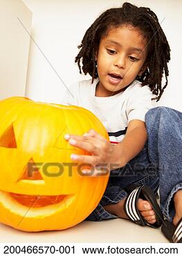 Stock Photography - young boy (2-4) 
playing with pumpkin 
face, low angle 
view. fotosearch 
- search stock 
photos, pictures, 
images, and photo 
clipart