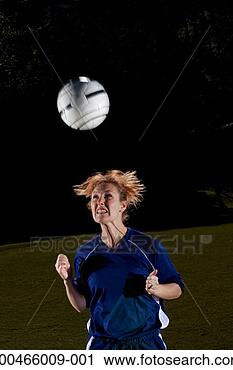 Stock Photography - young woman heading 
football, night. 
fotosearch - search 
stock photos, 
pictures, images, 
and photo clipart