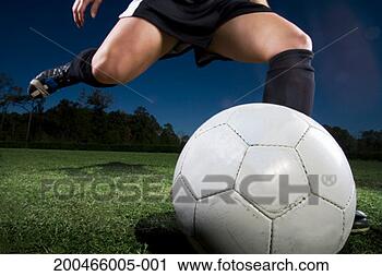 Stock Photography - young woman kicking 
football, close-up, 
low section. fotosearch 
- search stock 
photos, pictures, 
images, and photo 
clipart