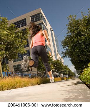 Stock Photography - young woman running 
on footpath, low 
angle, rear view. 
fotosearch - search 
stock photos, 
pictures, images, 
and photo clipart