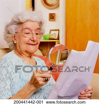 Stock Photography - senior woman reading 
document with 
magnifying glass. 
fotosearch - search 
stock photos, 
pictures, images, 
and photo clipart