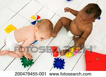 Stock Photography - two babies (9-18 
months) sitting 
on wooden floor, 
elevated view. 
fotosearch - search 
stock photos, 
pictures, images, 
and photo clipart