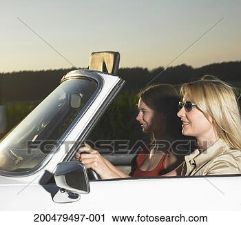 Stock Photography - two women driving 
in convertible 
car, smiling, 
side view, dusk. 
fotosearch - search 
stock photos, 
pictures, images, 
and photo clipart