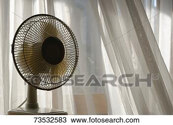Stock Photo - electric fan beside 
apartment window 
with white curtains. 
fotosearch - search 
stock photos, 
pictures, images, 
and photo clipart