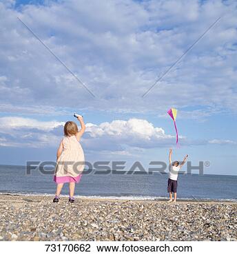 Stock Photo - faher and daughter 
(2-3) flying kite 
on beach. fotosearch 
- search stock 
photos, pictures, 
images, and photo 
clipart