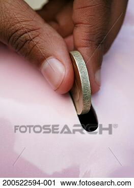 Stock Photography - girl (11-13) inserting 
coin into piggy 
bank, close-up 
of fingers. fotosearch 
- search stock 
photos, pictures, 
images, and photo 
clipart