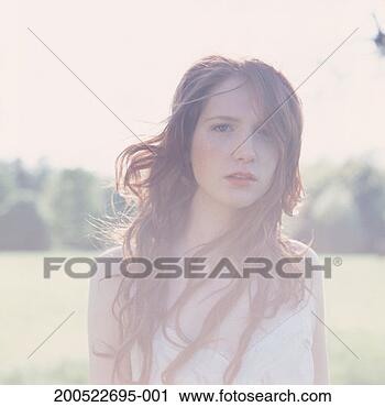 Stock Photography - young woman in 
field, close-up, 
portrait, (high 
key). fotosearch 
- search stock 
photos, pictures, 
images, and photo 
clipart