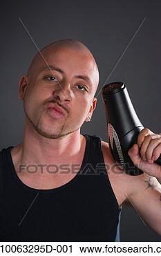 Stock Photography - portrait of young 
man with shaved 
head holding hair 
dryer as gun. 
fotosearch - search 
stock photos, 
pictures, images, 
and photo clipart
