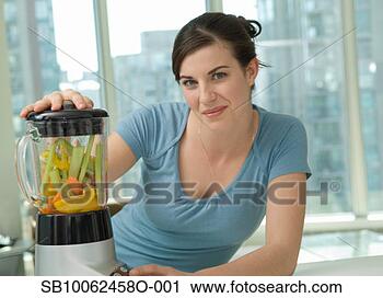 Stock Photography - young woman juicing 
vegetables, smiling, 
portrait. fotosearch 
- search stock 
photos, pictures, 
images, and photo 
clipart