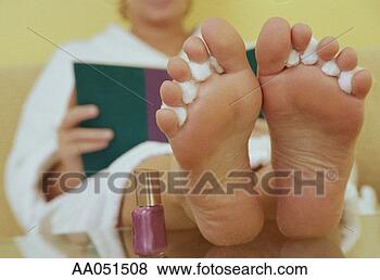 Stock Photo - nail polish dries 
on woman's feet 
while she reads 
a book. fotosearch 
- search stock 
photos, pictures, 
images, and photo 
clipart