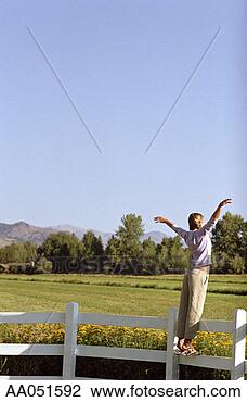 Stock Photo - teen girl standing 
on fence, arms 
raised. fotosearch 
- search stock 
photos, pictures, 
images, and photo 
clipart