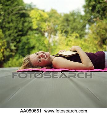 Stock Photography - woman lying on 
back with book 
resting on chest. 
fotosearch - search 
stock photos, 
pictures, images, 
and photo clipart