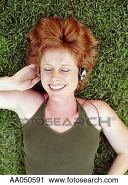 Stock Photography - woman lying on 
grass listening 
to music on headphones. 
fotosearch - search 
stock photos, 
pictures, images, 
and photo clipart