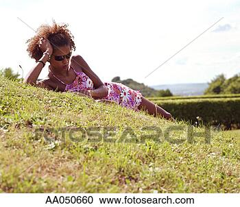 Stock Photography - woman lying on 
the grass and 
reading a book. 
fotosearch - search 
stock photos, 
pictures, images, 
and photo clipart