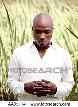 Stock Photography - young man, clasping 
hands, looking 
down. fotosearch 
- search stock 
photos, pictures, 
images, and photo 
clipart