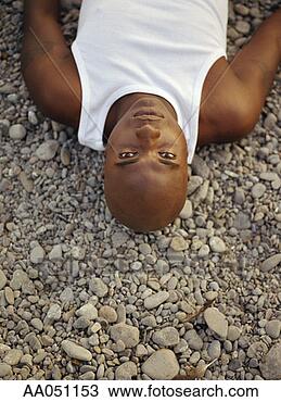 Stock Photo - young man lying 
on pebbles. fotosearch 
- search stock 
photos, pictures, 
images, and photo 
clipart