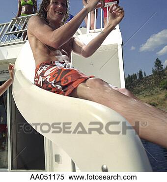 Stock Image - young man sliding 
down water slide, 
low angle view. 
fotosearch - search 
stock photos, 
pictures, images, 
and photo clipart