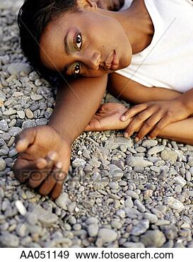 Stock Photograph - young man and 
young woman lying 
on rocky beach. 
fotosearch - search 
stock photos, 
pictures, images, 
and photo clipart