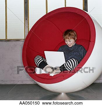 Stock Photography - woman using a 
laptop in a spherical 
chair. fotosearch 
- search stock 
photos, pictures, 
images, and photo 
clipart