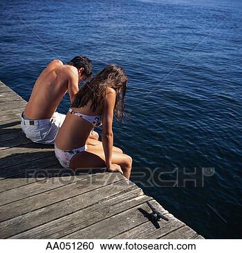 Stock Photography - teen boy and girl 
(14-16) sitting 
on edge of dock. 
fotosearch - search 
stock photos, 
pictures, images, 
and photo clipart