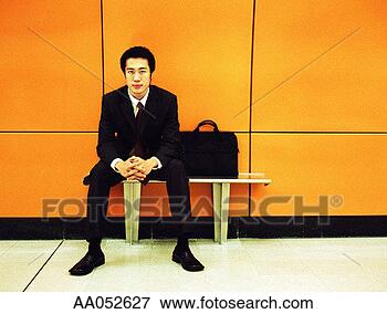Picture - young businessman 
sitting next to 
briefcase on bench. 
fotosearch - search 
stock photos, 
pictures, images, 
and photo clipart