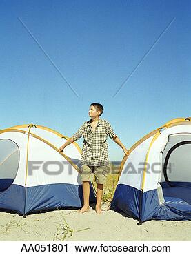 Stock Photography - boy (11-13) standing 
in between two 
dome tents. fotosearch 
- search stock 
photos, pictures, 
images, and photo 
clipart