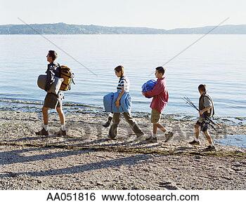 Stock Photo - family walking 
along beach carrying 
camping gear, 
side view. fotosearch 
- search stock 
photos, pictures, 
images, and photo 
clipart