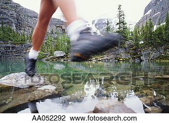 Stock Photo - hiker stepping 
on stones through 
stream, low section 
(blurred motion). 
fotosearch - search 
stock photos, 
pictures, images, 
and photo clipart