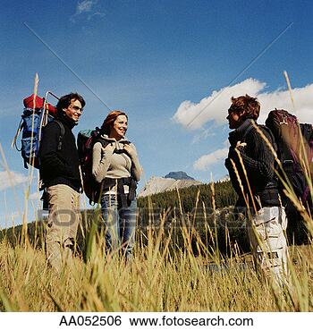 Stock Photo - three young adult 
hikers wearing 
backpacks, standing 
in tall grass. 
fotosearch - search 
stock photos, 
pictures, images, 
and photo clipart