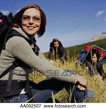 Picture - three young adult 
hikers sitting 
in tall grass 
(selective focus). 
fotosearch - search 
stock photos, 
pictures, images, 
and photo clipart