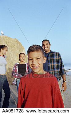 Stock Photo - young boy (8-10) 
standing on beach 
with family (selective 
focus). fotosearch 
- search stock 
photos, pictures, 
images, and photo 
clipart