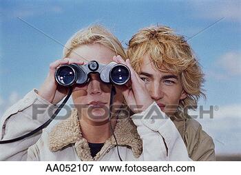 Picture - young woman looking 
through binoculars, 
young man behind 
her. fotosearch 
- search stock 
photos, pictures, 
images, and photo 
clipart