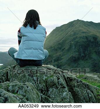 Stock Photograph - young woman sitting 
on rock, rear 
view, north wales, 
uk. fotosearch 
- search stock 
photos, pictures, 
images, and photo 
clipart