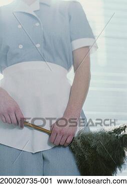 Stock Photography - uniformed maid 
holding feather 
duster, mid section, 
low angle view. 
fotosearch - search 
stock photos, 
pictures, images, 
and photo clipart