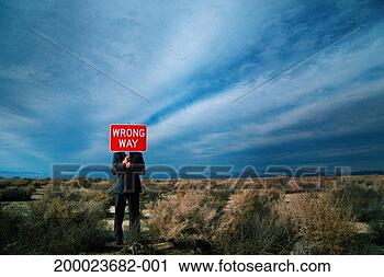 Stock Photography - businessman in 
desert holding 
street sign reading 
'wrong way'. fotosearch 
- search stock 
photos, pictures, 
images, and photo 
clipart