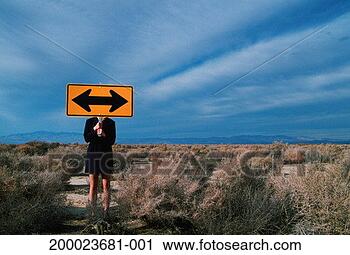 Stock Photography - businesswoman 
in desert holding 
directional arrow 
street sign. fotosearch 
- search stock 
photos, pictures, 
images, and photo 
clipart
