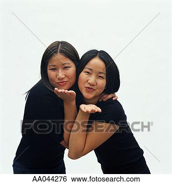Stock Photo - two young asian 
women, blowing 
kisses. fotosearch 
- search stock 
photos, pictures, 
images, and photo 
clipart