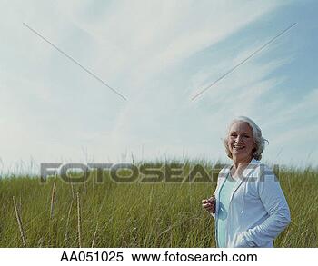 Stock Image - senior woman standing 
in field. fotosearch 
- search stock 
photos, pictures, 
images, and photo 
clipart