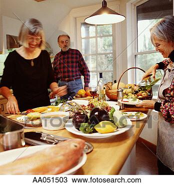 Stock Photo - three mature adults 
prepare food in 
kitchen. fotosearch 
- search stock 
photos, pictures, 
images, and photo 
clipart