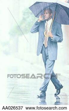 Picture - businessman with 
a cellular phone 
in rain. fotosearch 
- search stock 
photos, pictures, 
images, and photo 
clipart