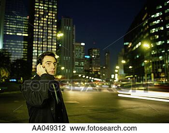 Stock Photo - businessman using 
a mobile phone 
in the city of 
buenos aires at 
night. fotosearch 
- search stock 
photos, pictures, 
images, and photo 
clipart