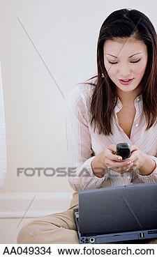 Stock Photo - woman using mobile 
phone with laptop 
computer. fotosearch 
- search stock 
photos, pictures, 
images, and photo 
clipart