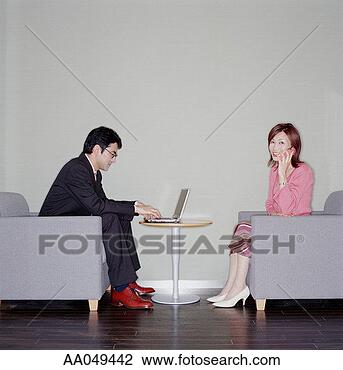 Stock Photo - young businesswoman 
on phone and businessman 
on computer, side 
view. fotosearch 
- search stock 
photos, pictures, 
images, and photo 
clipart