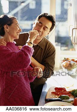 Stock Photo - mature couple 
in kitchen, woman 
feeding man food. 
fotosearch - search 
stock photos, 
pictures, images, 
and photo clipart