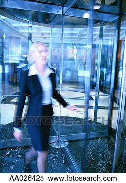 Stock Image - businesswoman 
walking through 
a revolving door. 
fotosearch - search 
stock photos, 
pictures, images, 
and photo clipart