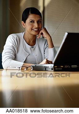 Stock Photo - woman sitting 
at desk with laptop, 
portrait. fotosearch 
- search stock 
photos, pictures, 
images, and photo 
clipart