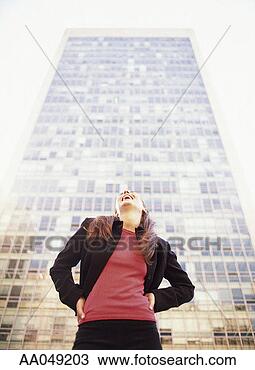 Stock Photo - woman standing 
in front of office 
building smiling, 
low angle view. 
fotosearch - search 
stock photos, 
pictures, images, 
and photo clipart