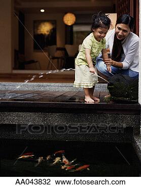 Stock Photo - mother and daughter 
(2-4) playing 
beside pond filled 
with koi carp. 
fotosearch - search 
stock photos, 
pictures, images, 
and photo clipart